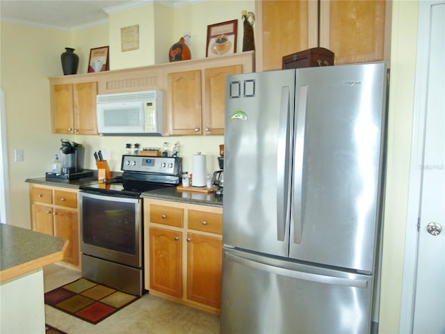 kitchen with stainless steel appliances, dark countertops, and crown molding