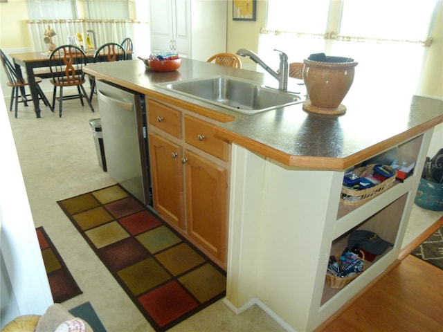 kitchen with brown cabinetry, dishwasher, and a sink