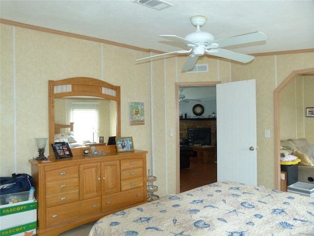 bedroom with visible vents, crown molding, and a fireplace