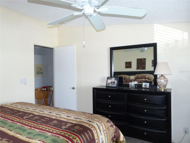 bedroom with a ceiling fan and a textured ceiling