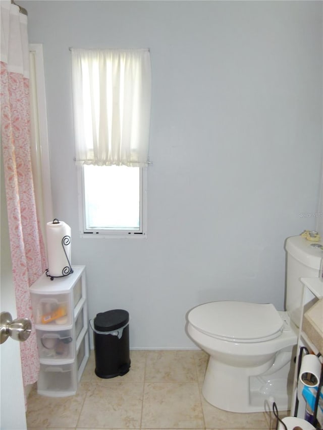 full bathroom with a shower with shower curtain, tile patterned flooring, and toilet