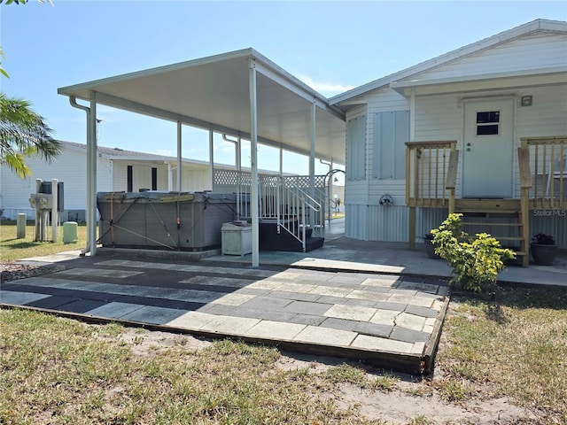 1601 US Highway 441 SE Unit 24, Okeechobee, FL 34974 - rear view of house with a hot tub, a patio, and a carport
