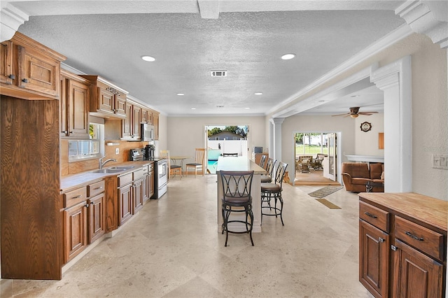 kitchen with visible vents, light countertops, decorative columns, appliances with stainless steel finishes, and a ceiling fan