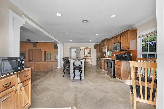 kitchen with visible vents, backsplash, ceiling fan, appliances with stainless steel finishes, and brown cabinetry