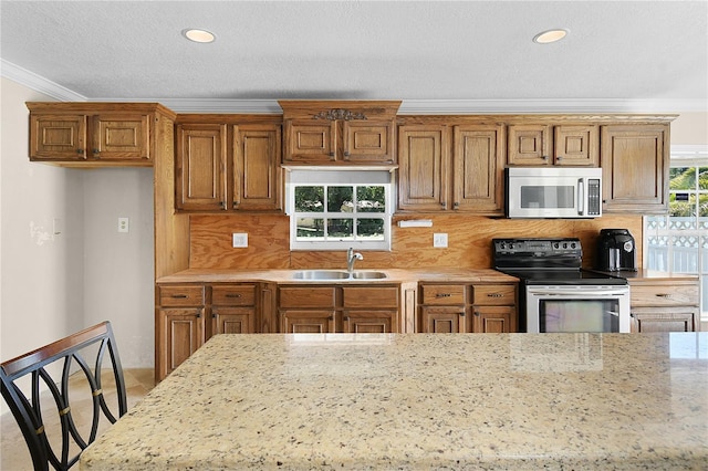 kitchen with a sink, stainless steel appliances, and brown cabinets