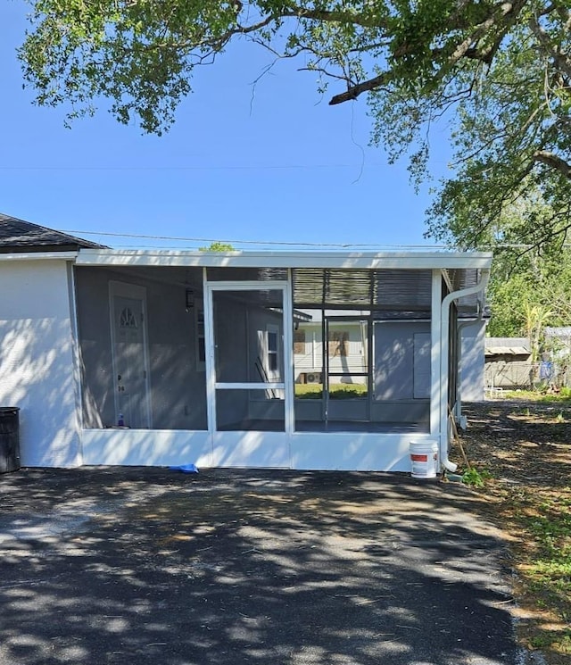 exterior space with a sunroom and stucco siding