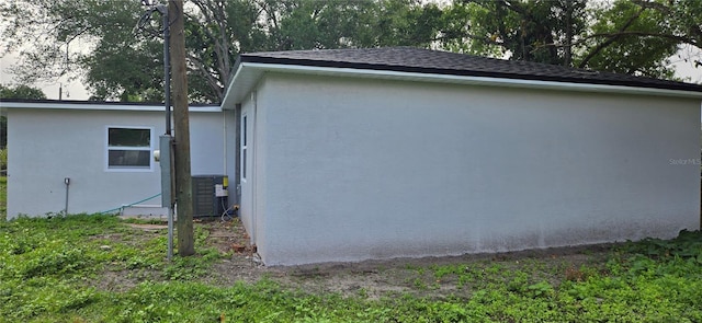 view of home's exterior with cooling unit and stucco siding