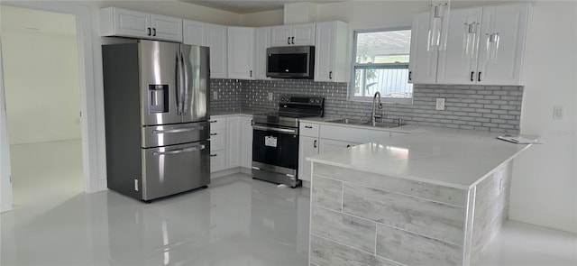 kitchen with light countertops, backsplash, a sink, stainless steel appliances, and white cabinets