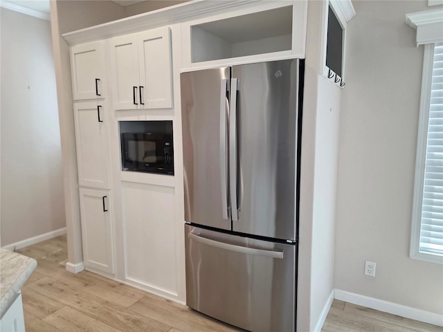 649 SW 34th Cv Unit 392, Okeechobee, FL 34974 - kitchen featuring freestanding refrigerator, black microwave, light wood-style flooring, and white cabinetry
