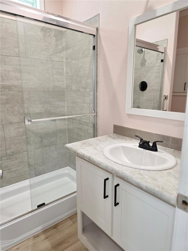 649 SW 34th Cv Unit 392, Okeechobee, FL 34974 - full bathroom featuring vanity, a tile shower, and wood finished floors