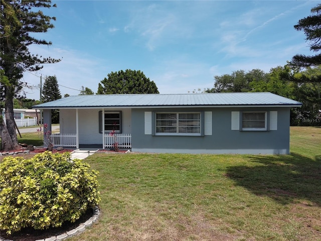 3007 SE 34th Ct, Okeechobee, FL 34974 - ranch-style home with covered porch, stucco siding, metal roof, and a front lawn