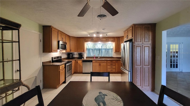 3007 SE 34th Ct, Okeechobee, FL 34974 - kitchen with dark countertops, light tile patterned flooring, appliances with stainless steel finishes, and a sink