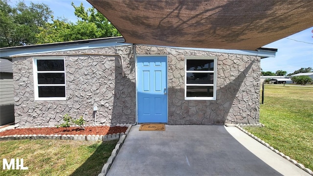 3007 SE 34th Ct, Okeechobee, FL 34974 - doorway to property with a lawn and stone siding
