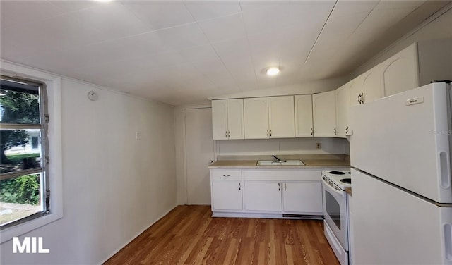 3007 SE 34th Ct, Okeechobee, FL 34974 - kitchen featuring white appliances, a sink, wood finished floors, light countertops, and white cabinets