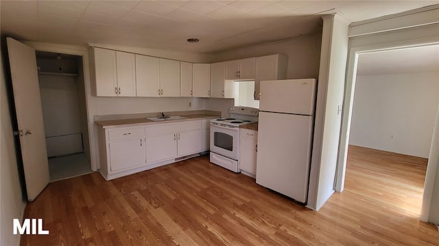3007 SE 34th Ct, Okeechobee, FL 34974 - kitchen featuring a sink, light wood-style flooring, white appliances, and white cabinets