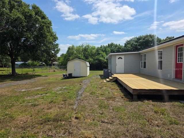 7895 NW 84th Ct, Okeechobee, FL 34972 - view of yard with fence, a storage unit, a wooden deck, and an outbuilding