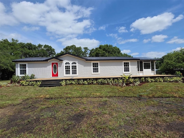 7895 NW 84th Ct, Okeechobee, FL 34972 - manufactured / mobile home featuring a sunroom, a wooden deck, a front yard, and metal roof
