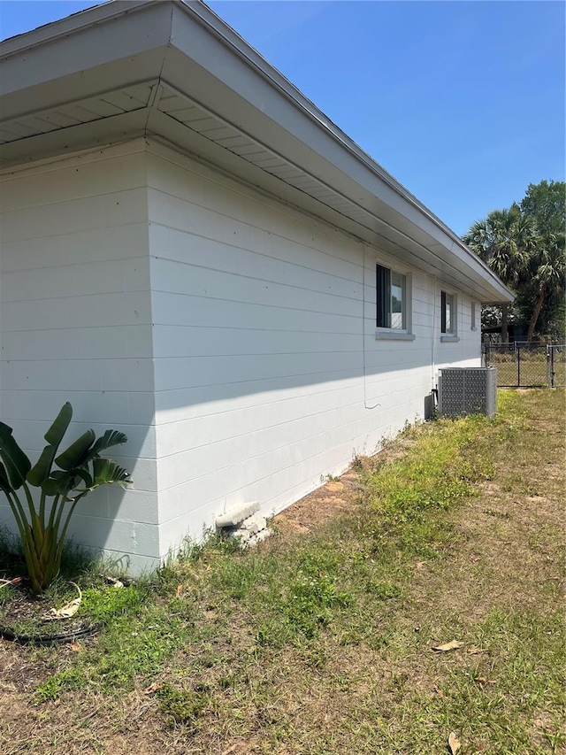 view of side of property featuring cooling unit and concrete block siding