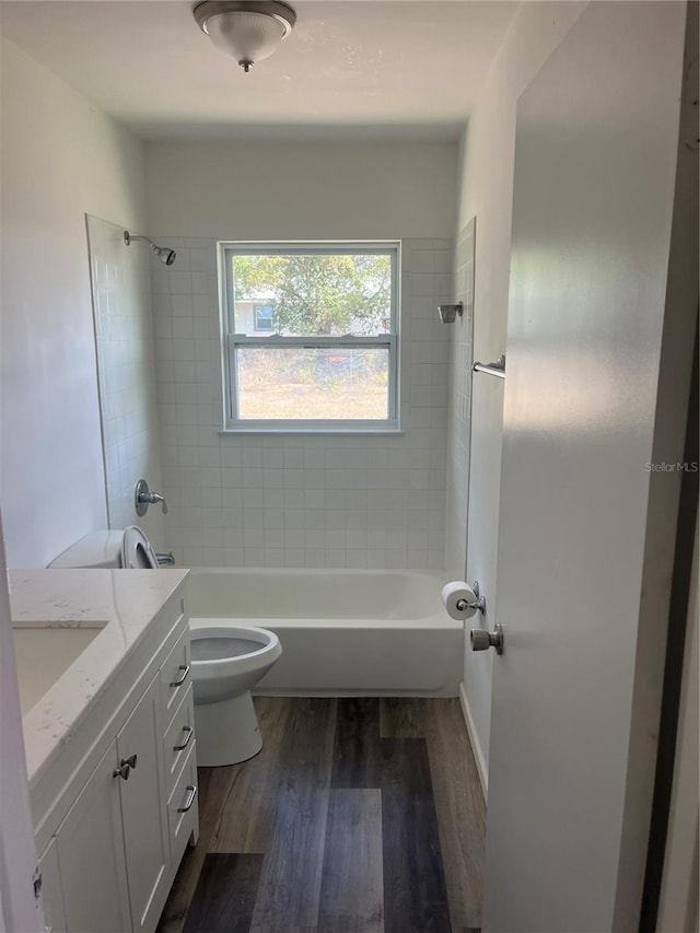 full bath featuring wood finished floors, bathtub / shower combination, and toilet