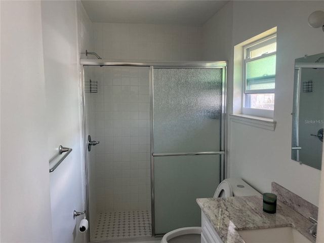 bathroom featuring a shower stall, toilet, and vanity