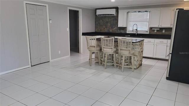 1066 5th St, Okeechobee, FL 34974 - kitchen featuring freestanding refrigerator, a sink, a wall unit AC, ornamental molding, and tasteful backsplash