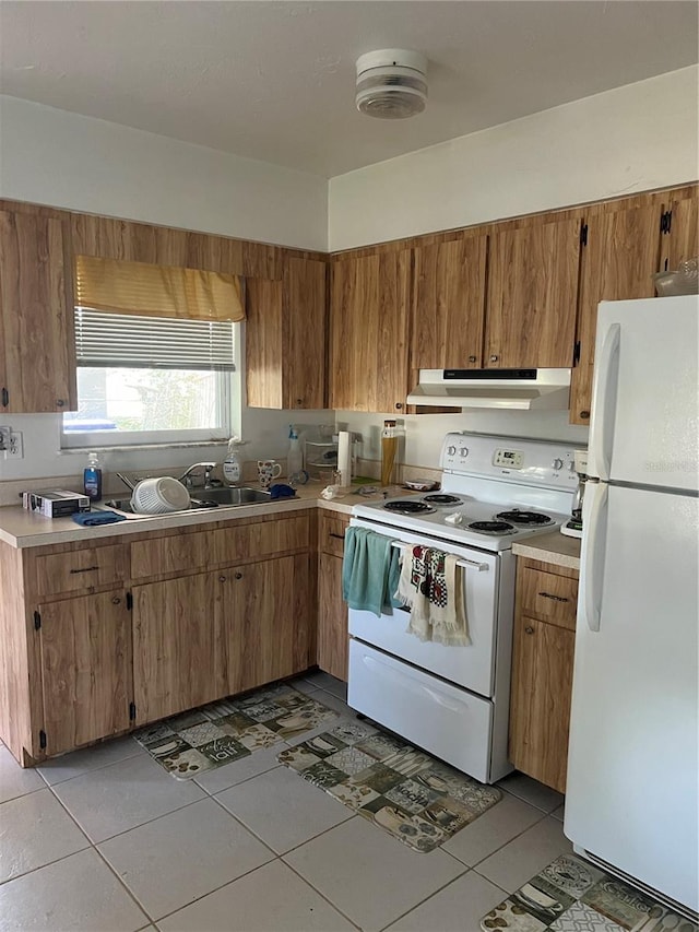 508 NW 17th St, Okeechobee, FL 34972 - kitchen with white appliances, under cabinet range hood, light countertops, and light tile patterned floors