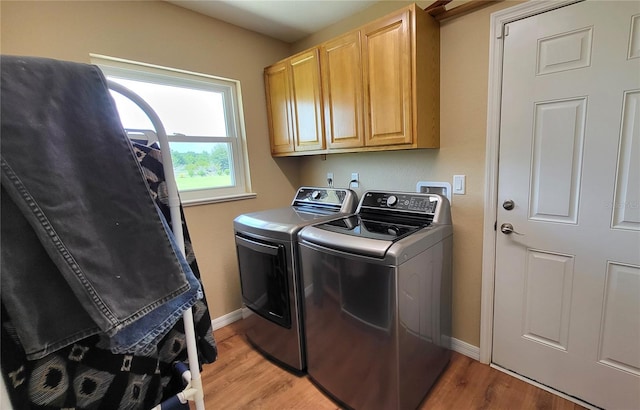 16159 NW 258th St, Okeechobee, FL 34972 - washroom featuring washing machine and dryer, cabinet space, light wood-style floors, and baseboards