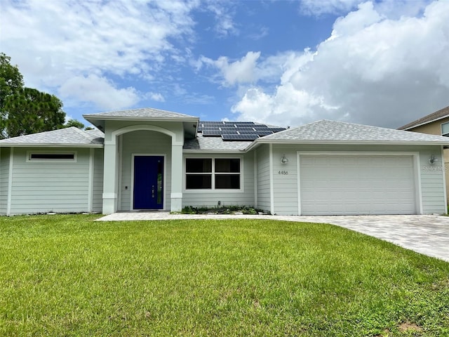 4486 SW Cacao St, Port St Lucie, FL 34953 - ranch-style home featuring an attached garage, solar panels, a front yard, driveway, and a shingled roof