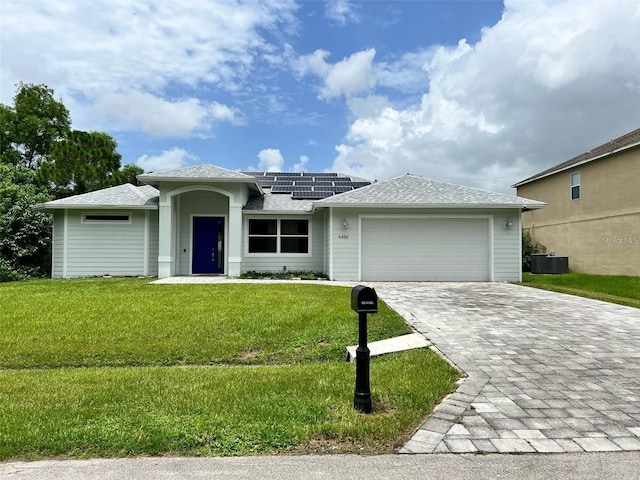 4486 SW Cacao St, Port St Lucie, FL 34953 - ranch-style house with an attached garage, solar panels, a front yard, cooling unit, and roof with shingles