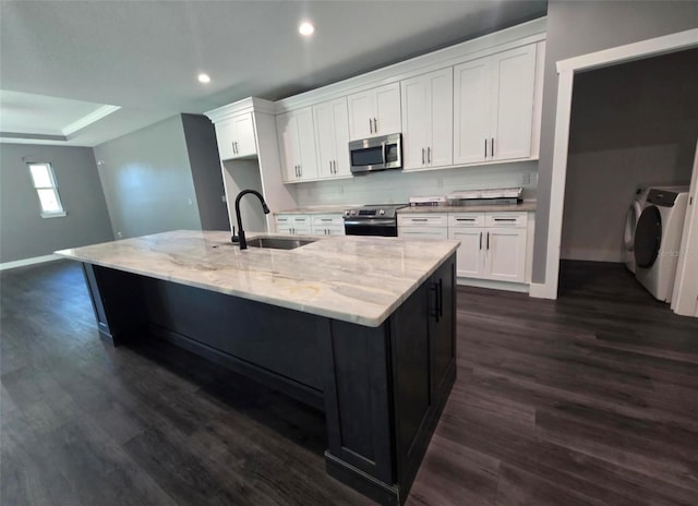 4486 SW Cacao St, Port St Lucie, FL 34953 - kitchen featuring appliances with stainless steel finishes, washing machine and clothes dryer, a sink, dark wood-style flooring, and recessed lighting