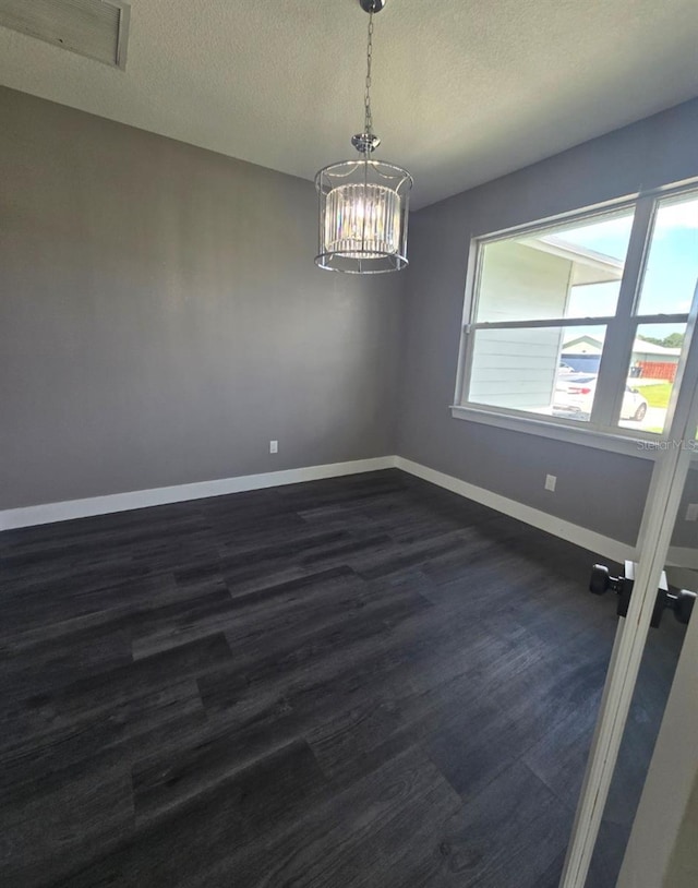 4486 SW Cacao St, Port St Lucie, FL 34953 - spare room featuring baseboards, dark wood-style flooring, a chandelier, and a textured ceiling