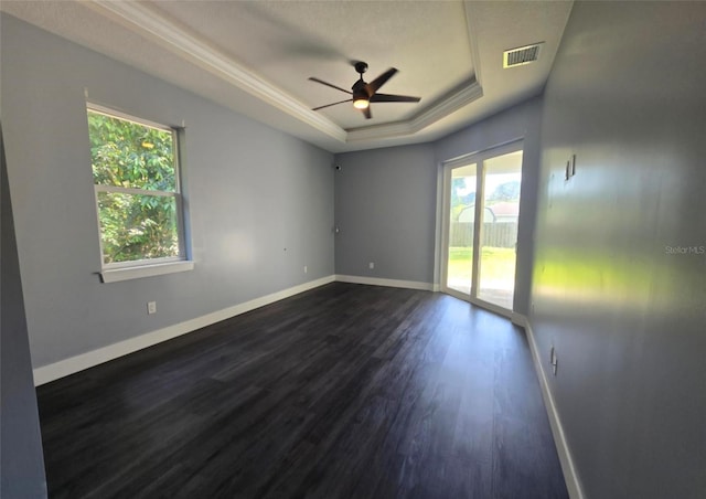 4486 SW Cacao St, Port St Lucie, FL 34953 - empty room with a tray ceiling, plenty of natural light, dark wood-style flooring, ceiling fan, and crown molding