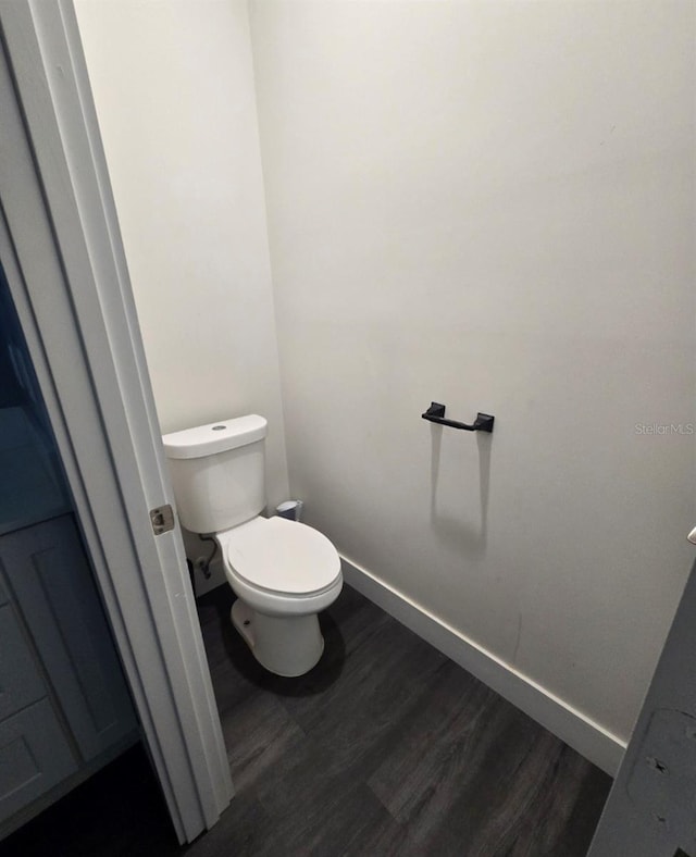 4486 SW Cacao St, Port St Lucie, FL 34953 - bathroom featuring wood finished floors, baseboards, and toilet