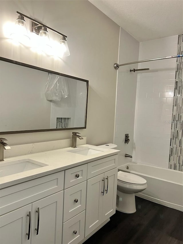 4486 SW Cacao St, Port St Lucie, FL 34953 - full bath with wood finished floors, toilet, double vanity, shower / bath combination, and a textured ceiling