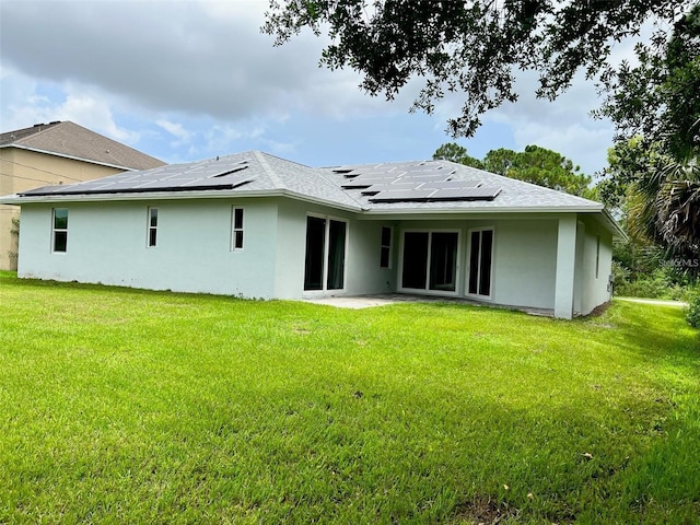 4486 SW Cacao St, Port St Lucie, FL 34953 - back of property with roof mounted solar panels, a lawn, stucco siding, and a patio area