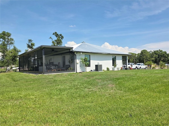 7935 NW 90th Ct, Okeechobee, FL 34972 - rear view of property with a sunroom, central air condition unit, a yard, and stucco siding
