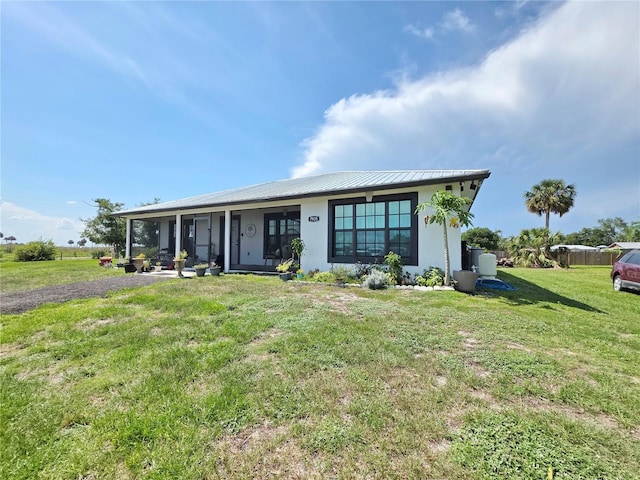 7935 NW 90th Ct, Okeechobee, FL 34972 - view of front of house with a front lawn, stucco siding, and metal roof