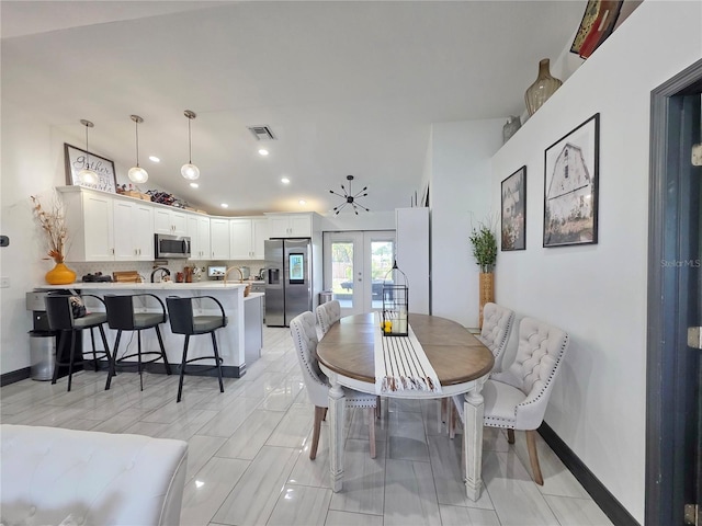 7935 NW 90th Ct, Okeechobee, FL 34972 - dining area featuring french doors, vaulted ceiling, recessed lighting, and baseboards