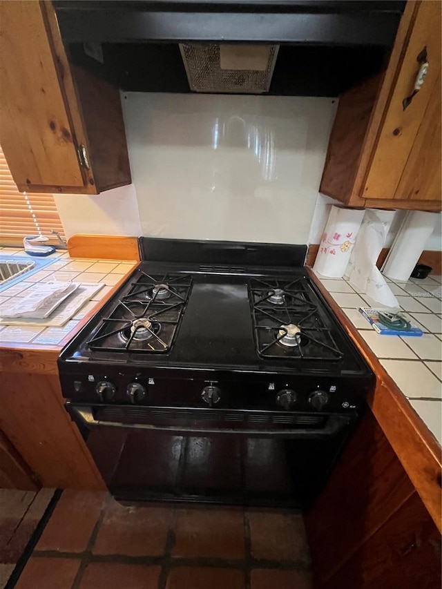 1096 8th St, Okeechobee, FL 34974 - kitchen featuring black range with gas cooktop and tile countertops