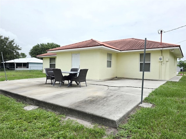 3897 NW 22nd Ave, Okeechobee, FL 34972 - back of house featuring stucco siding, a patio, a yard, and metal roof