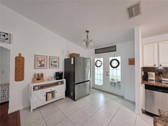 3897 NW 22nd Ave, Okeechobee, FL 34972 - kitchen with stainless steel appliances, french doors, a chandelier, light tile patterned flooring, and a textured ceiling