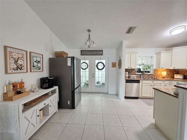 3897 NW 22nd Ave, Okeechobee, FL 34972 - kitchen with appliances with stainless steel finishes, tasteful backsplash, white cabinetry, a textured ceiling, and french doors