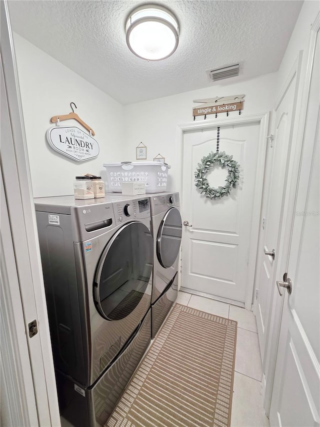 3897 NW 22nd Ave, Okeechobee, FL 34972 - laundry room featuring separate washer and dryer, a textured ceiling, and light tile patterned floors