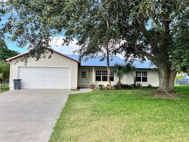 1150 SW 83rd Ave, Okeechobee, FL 34974 - ranch-style house featuring driveway, a garage, a front lawn, and a metal roof