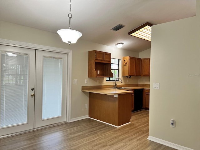 1150 SW 83rd Ave, Okeechobee, FL 34974 - kitchen with a peninsula, light countertops, black dishwasher, brown cabinetry, and light wood-style flooring