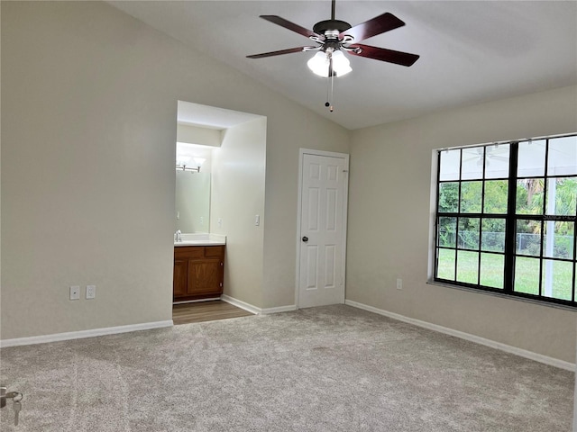 1150 SW 83rd Ave, Okeechobee, FL 34974 - unfurnished bedroom featuring carpet flooring, vaulted ceiling, ensuite bath, and ceiling fan