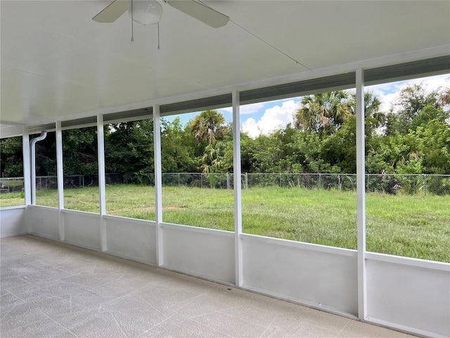 1150 SW 83rd Ave, Okeechobee, FL 34974 - unfurnished sunroom with ceiling fan, healthy amount of natural light, and view of wooded area