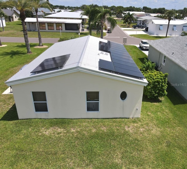 1000 SW 44th Blvd, Okeechobee, FL 34974 - view of side of home with roof mounted solar panels, a residential view, and a lawn