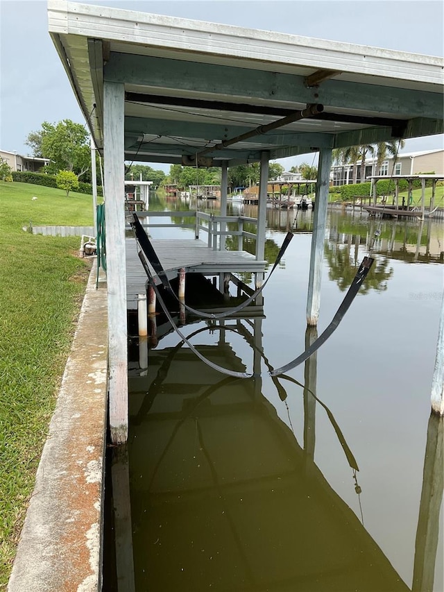2438 SE 32nd St, Okeechobee, FL 34974 - dock area with boat lift, a water view, and a lawn