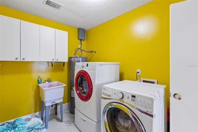 402 SW Seaflower Ter, Port St Lucie, FL 34984 - laundry area with cabinet space, washing machine and clothes dryer, light marble finish flooring, water heater, and a textured ceiling